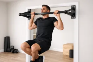 Athlète effectuant une traction sécurisée sur une barre de traction solide dans un intérieur domestique propre et lumineux, illustrant un équipement fiable pour le calisthenics à domicile.